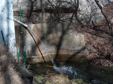 Water on side of building emptying into springs